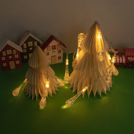 Minimalistic Christmas tree with lights and christmas figurines on green background. New Year minimal concept.の写真素材