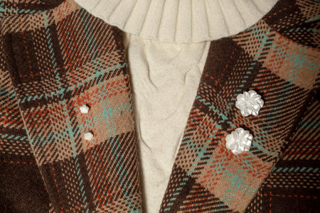 Florals white earrings on the lapels of a brown coat with a white sweater. Creative fashion ideaの写真素材