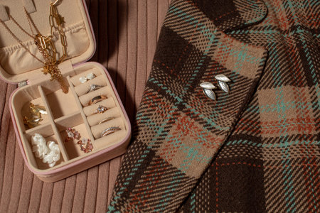 Jewelry box, earrings on the lapel of a brown coat and a mocha sweater. Creative fashion idea