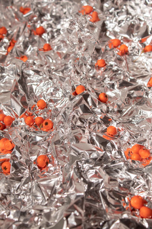 Background of crumpled aluminum foil and scattered fire thornの写真素材