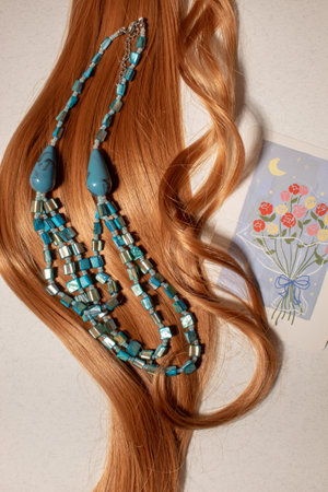 Hair with invitation card and blue necklace. Creative concept of modern styling.の写真素材