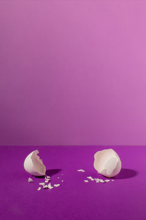 Empty eggshell on pastel purple background. Minimal Easter holiday concept.の写真素材
