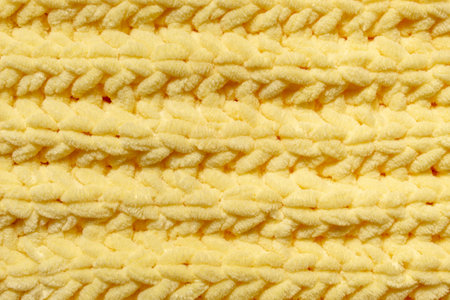 Winter wool hand-knit yellow sweater. Clothes textile background