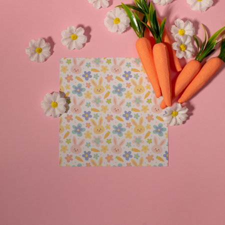 Easter pattern made with carrots and flowers on pastel pink background. Creative minimal holiday concept. Copy spaceの写真素材