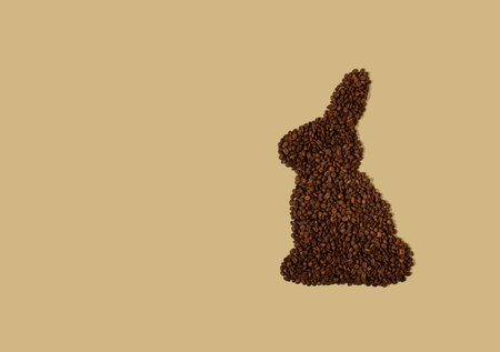 Easter bunny made of a coffee beans on a light beige background with copy space. Easter minimalism.の写真素材