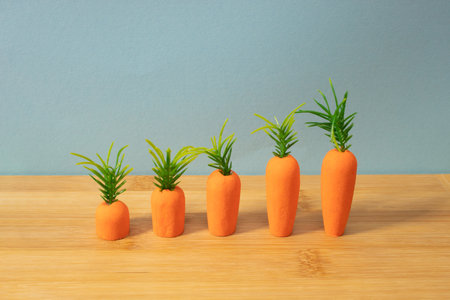 Carrots on wooden background. Minimal Easter concept. Spring minimal composition.の写真素材