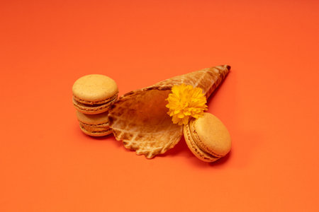 Ice cream cone and macaroons on orange background. Minimal summer concept. Flat lay.の写真素材