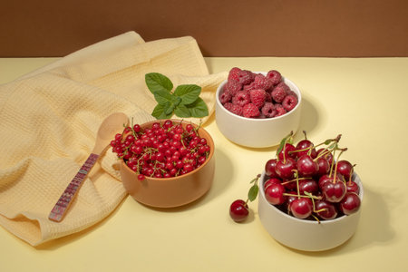 Red fruits of currants, raspberries and cherries in bowls. Health concept. Copy spaceの写真素材