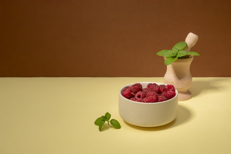 Red fruit of raspberry in bowl and mint. Health concept. Copy space