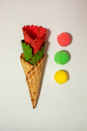 Multicolored cones and ice cream scoops on grey backround. Vibrant colorsの写真素材