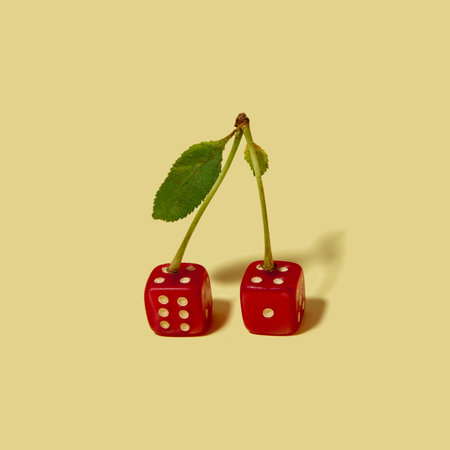 Cheries made of gambling dice on beige background. Funky fruits for gambling isolated in studio.の写真素材
