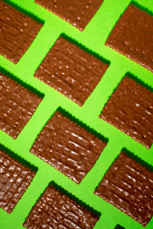 Diagonally arranged chocolate biscuit on a green background.の写真素材