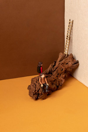 Miniature people sitting on a tree. Hiking. Mountaineering. Adventureの写真素材
