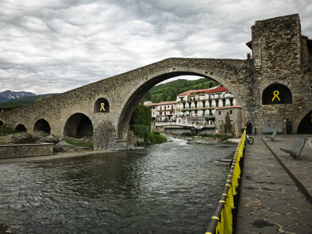 Old medieval stone bridge with yellow ties in Camprodon, Girona, Spainの写真素材