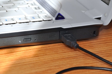Close-up detail of a laptop and usb cableの写真素材