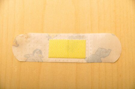 The used plaster-aid, on the wooden floorの写真素材