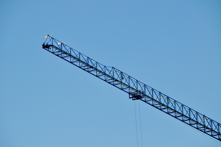 Closeup of blue jib crane against blue skyの写真素材