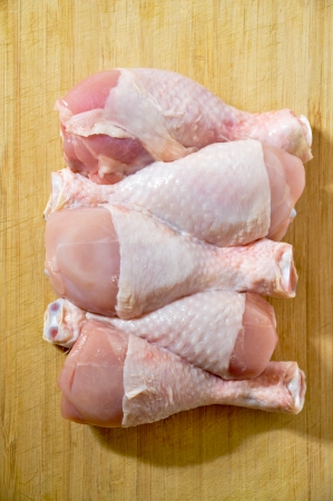 Fresh raw chicken legs on wooden board の写真素材