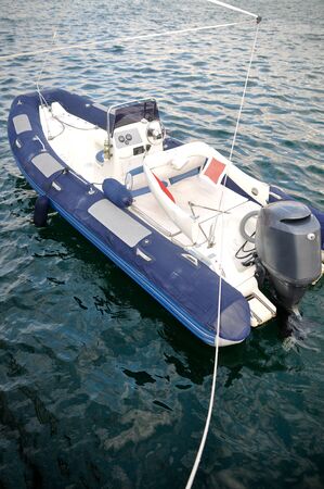 Modern inflatable boat with engine in the sea near shore