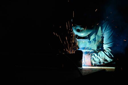 Welder uses torch to make sparks during manufacture of metal equipmentの写真素材