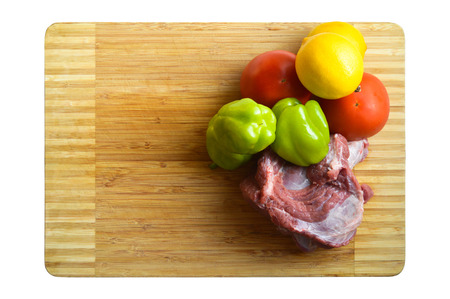 Fresh vegetables and red raw meat on the cutting boardの写真素材