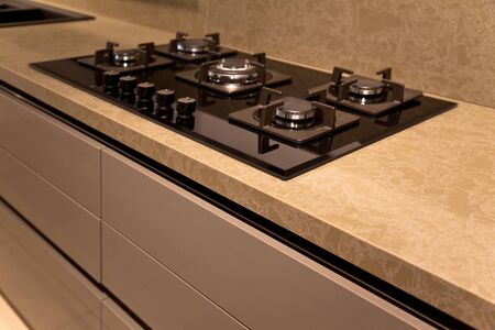 Interior of luxurious modern kitchen equipment and black glass ceramic built-in gas oven