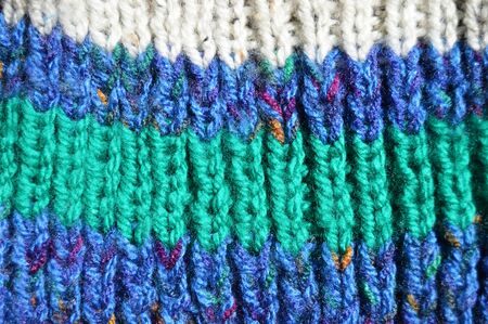 Pattern fabric made of wool. Handmade knitted fabric colored wool background texture