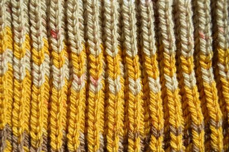 Pattern fabric made of wool. Handmade knitted fabric yellow wool background texture