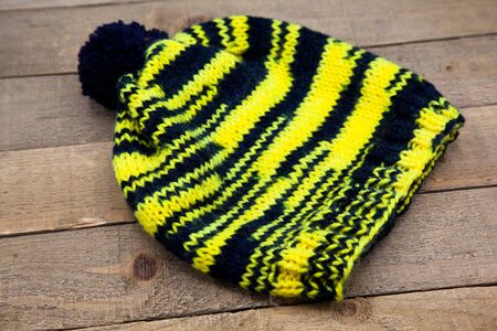 Handmade wool knitted winter hat and scarf isolated on old wood background