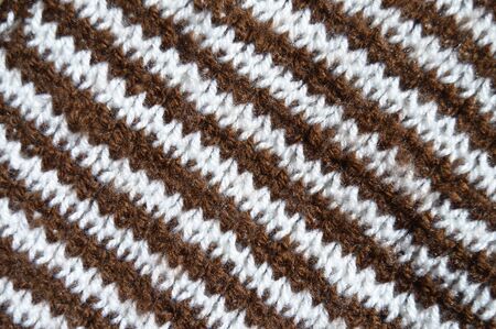 Pattern fabric made of wool. Handmade knitted fabric brown white wool background texture