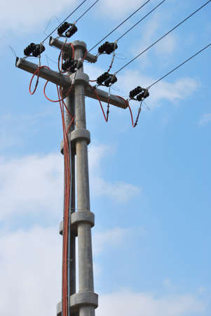 High voltage electricity cables detail over a clean blue sky, high voltage electric concrete pillar