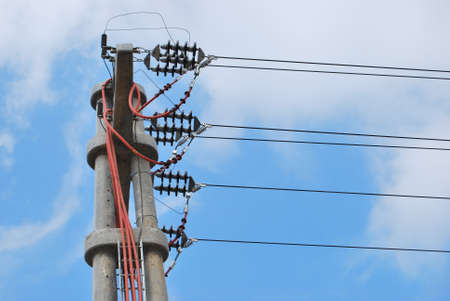 High voltage electricity cables detail over a clean blue sky, high voltage electric concrete pillarの写真素材