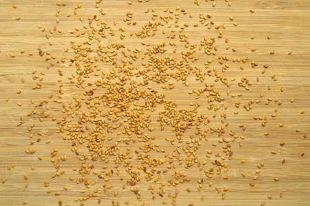 Roasted fresh organic sesame seeds texture, on bamboo cutting board