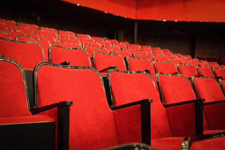 Modern cinema hall empty and red comfortable seats, movie theater seats or chairの写真素材