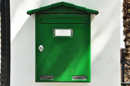 Vintage metal green mailbox near the entrance door of a luxury houseの写真素材