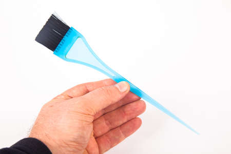 Blue plastic bristle brush used for hair coloring in hairdressers