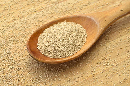 Active granulated yeast, instant dry sourdough, on a bamboo cutting board in wooden spoonの写真素材