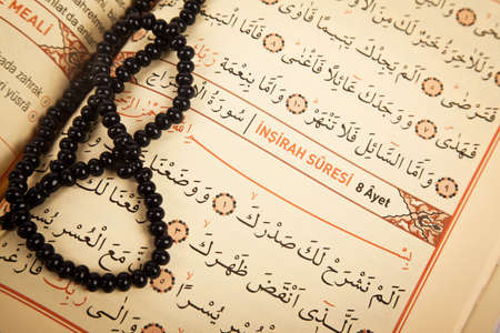 Pages and verses from the holy book of islam religion quran and black rosary, kuran and chapters,...