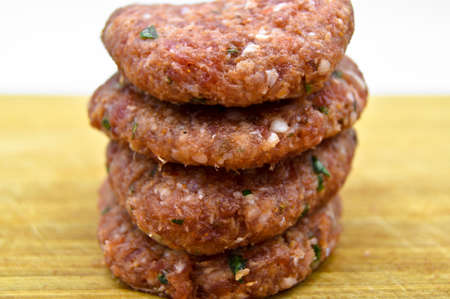 Raw beef meatballs made with various homemade spices, beef kofte kofta raw, on bamboo cutting board
