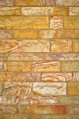 Sturdy yellow and beige cut stone wall, good for backgrounds, seamless lined up