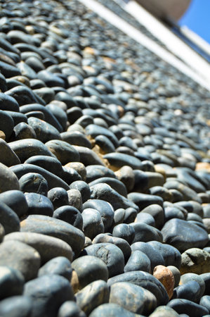 Wall texture decorated with blue pebbles, pebbles glued to the wall, background pebble wall textureの写真素材