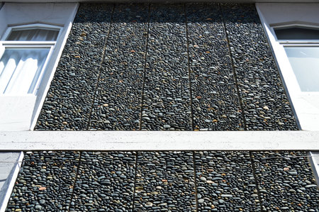 Wall texture decorated with blue pebbles, pebbles glued to the wall, background pebble wall texture