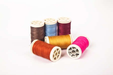 Spools and bobbins of thread for sewing in different colors, isolated on white background
