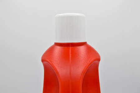 Plastic red detergent bottle, white cap cosmetic container, isolated on white backgroundの写真素材