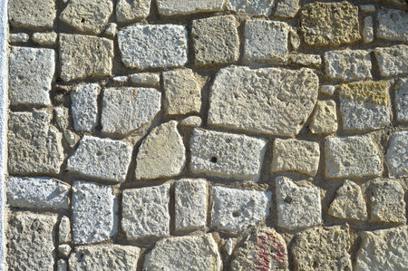 Sturdy yellow and beige cut stone wall, good for backgrounds, seamless lined upの写真素材
