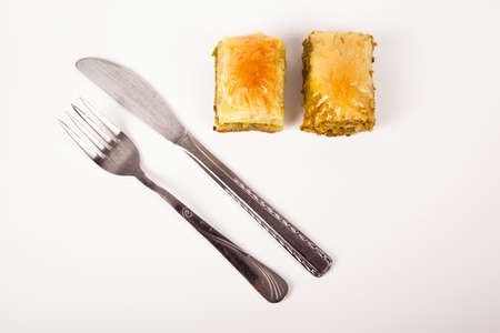 Baklava with pistachio, one of the most beautiful desserts of Turkish cuisine and metal fork knife. Turkish dessert baklavaの写真素材