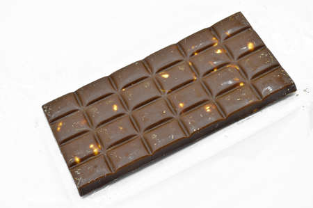 Delicious chocolate bar with milk and hazelnut sprinkles, isolated on white background