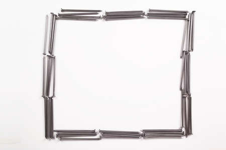 A lot of construction iron nails frame, industrial parts, isolated on white background