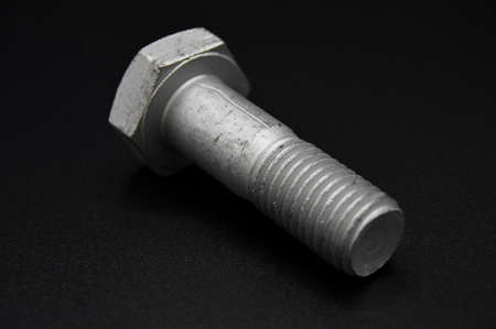 Galvanized steel metal with metric bolt, isolated on black background