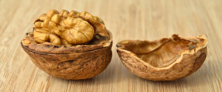 Healthy and nutritious beige brown walnut grains, bamboo on cutting board